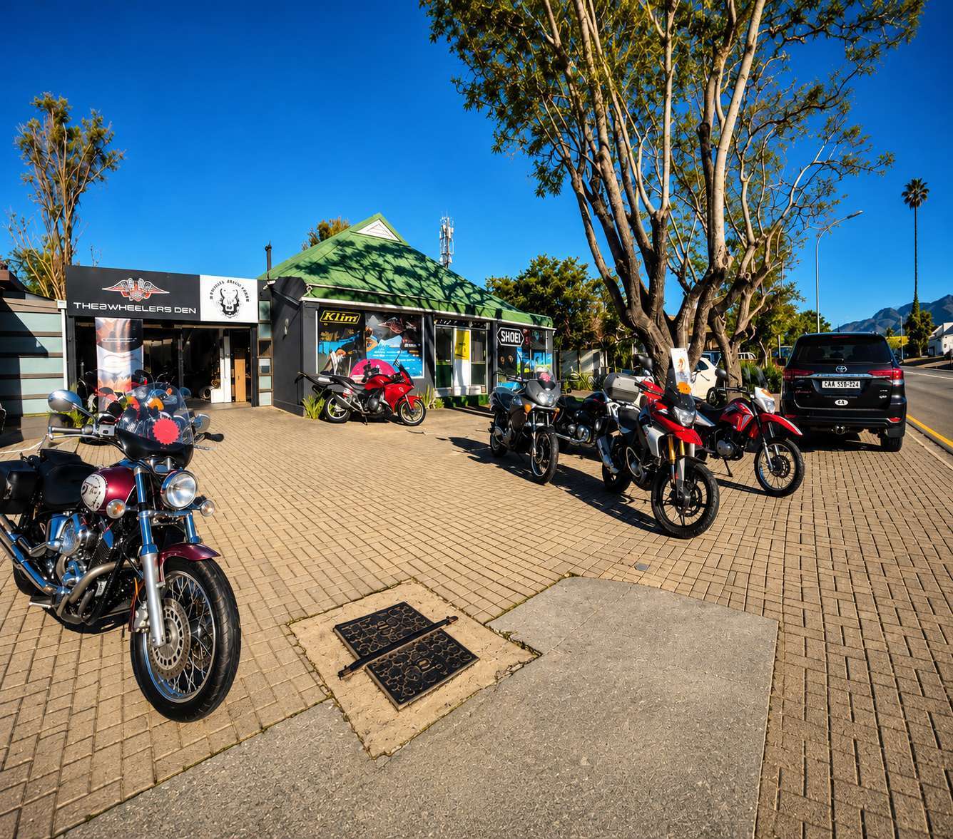 The 2Wheelers Den storefront with motorcycles outside